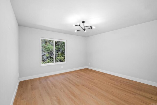 10594 Rookwood Dr, San Diego, CA 92131 - unfurnished room with a chandelier and light wood-style floors