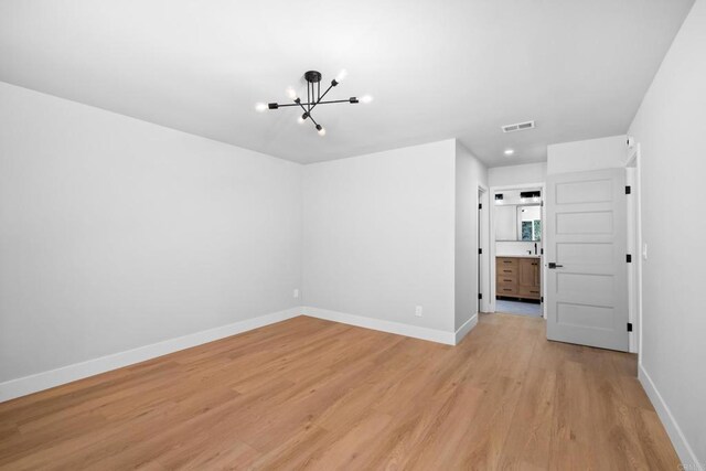10594 Rookwood Dr, San Diego, CA 92131 - empty room featuring a chandelier and light wood-style floors