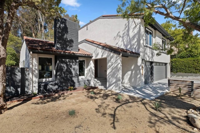 10594 Rookwood Dr, San Diego, CA 92131 - rear view of property with an attached garage, a chimney, concrete driveway, and stucco siding