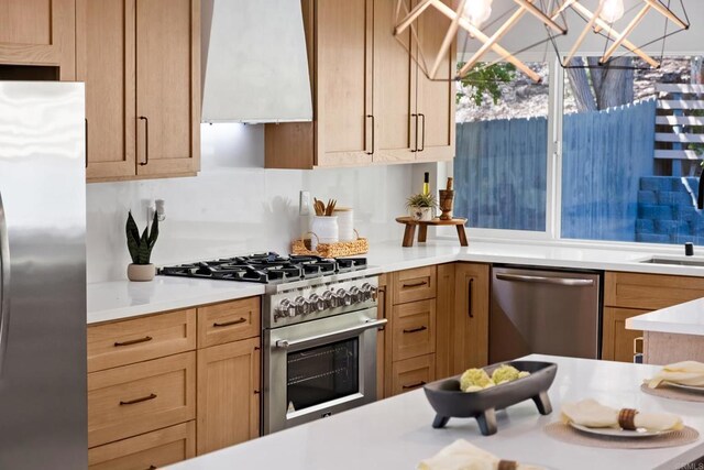 10594 Rookwood Dr, San Diego, CA 92131 - kitchen with appliances with stainless steel finishes, wall chimney range hood, light countertops, and a chandelier