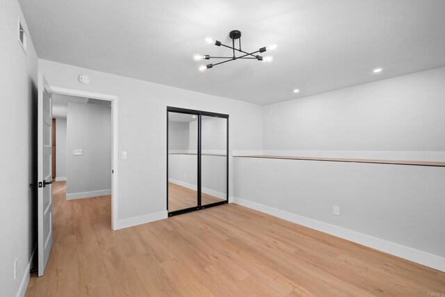 10594 Rookwood Dr, San Diego, CA 92131 - unfurnished bedroom featuring a chandelier, light wood-type flooring, a closet, and recessed lighting