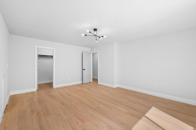 10594 Rookwood Dr, San Diego, CA 92131 - unfurnished bedroom featuring light wood-style floors, a chandelier, a spacious closet, and a closet