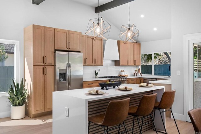 10594 Rookwood Dr, San Diego, CA 92131 - kitchen featuring stainless steel appliances, premium range hood, beamed ceiling, light wood-style flooring, and light countertops