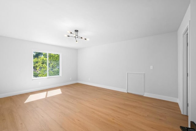 10594 Rookwood Dr, San Diego, CA 92131 - spare room with a chandelier and light wood-style floors
