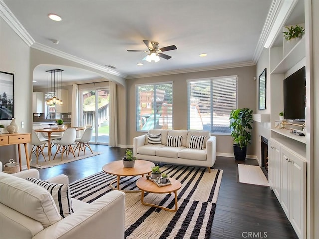 11961 Limestone Ct, Yucaipa, CA 92399 - living room with arched walkways, crown molding, dark wood-style floors, ceiling fan, and recessed lighting