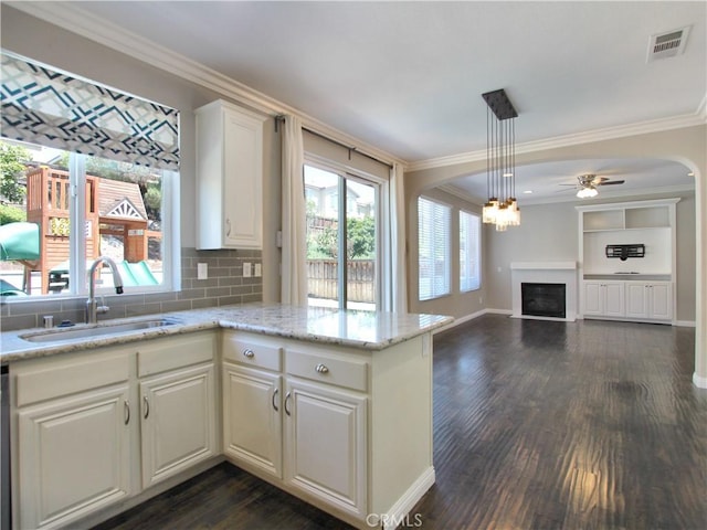 11961 Limestone Ct, Yucaipa, CA 92399 - kitchen with a fireplace, crown molding, dark wood-style floors, a ceiling fan, and white cabinetry