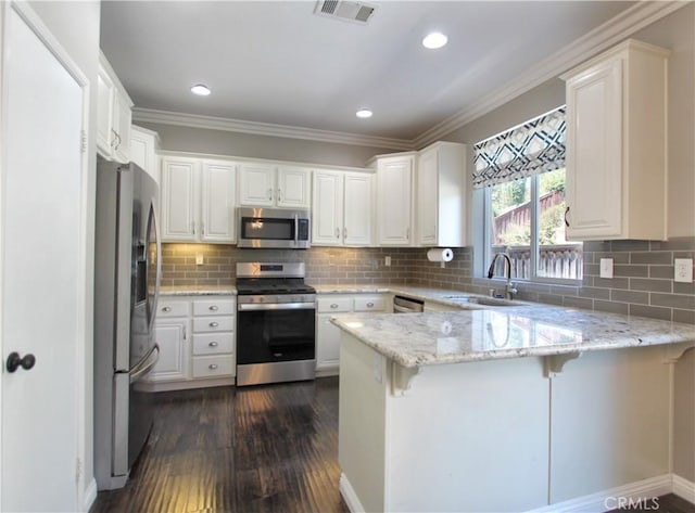 11961 Limestone Ct, Yucaipa, CA 92399 - kitchen with stainless steel appliances, a peninsula, dark wood-type flooring, crown molding, and light stone countertops
