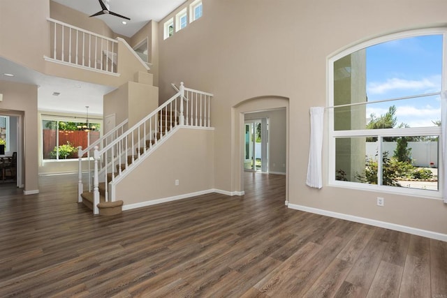 943 Masters Dr, Oceanside, CA 92057 - unfurnished living room with stairs, healthy amount of natural light, wood finished floors, a high ceiling, and a ceiling fan