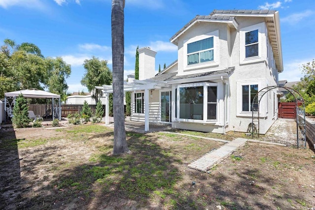 943 Masters Dr, Oceanside, CA 92057 - back of house with a gazebo, a pergola, a patio area, stucco siding, and a chimney