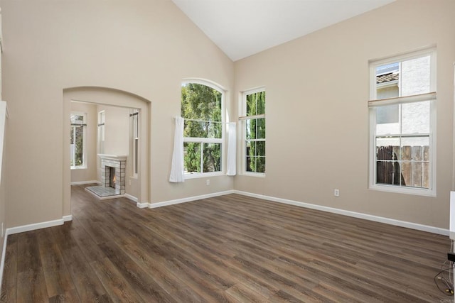 943 Masters Dr, Oceanside, CA 92057 - spare room featuring a warm lit fireplace, dark wood-type flooring, and high vaulted ceiling