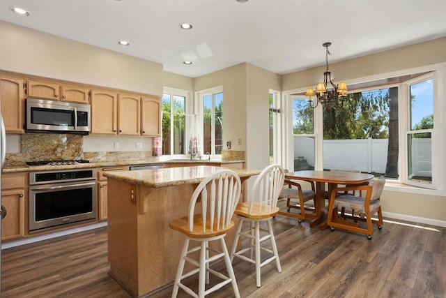 943 Masters Dr, Oceanside, CA 92057 - kitchen featuring stainless steel appliances, a chandelier, dark wood-style floors, light stone countertops, and a kitchen island