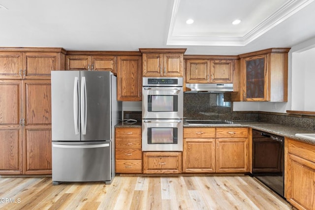 2524 Monaco Dr, Oxnard, CA 93035 - kitchen with black appliances, under cabinet range hood, a raised ceiling, brown cabinetry, and light wood-type flooring