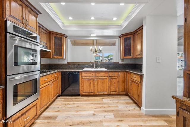 2524 Monaco Dr, Oxnard, CA 93035 - kitchen with black appliances, a raised ceiling, light wood-style floors, dark countertops, and brown cabinets