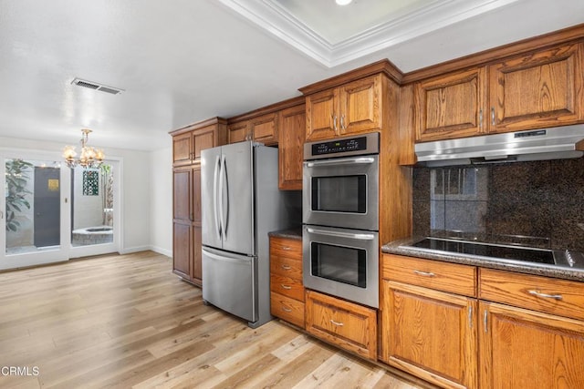 2524 Monaco Dr, Oxnard, CA 93035 - kitchen featuring stainless steel appliances, brown cabinetry, a chandelier, under cabinet range hood, and light wood finished floors