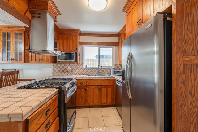 1219 221st St W, Torrance, CA 90502 - kitchen featuring appliances with stainless steel finishes, wall chimney range hood, tile countertops, brown cabinets, and ornamental molding