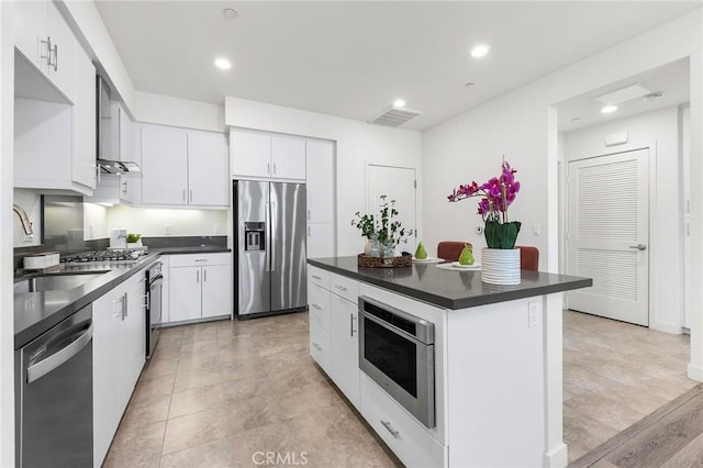 2526 Nolita, Irvine, CA 92612 - kitchen with appliances with stainless steel finishes, dark countertops, recessed lighting, white cabinets, and wall chimney exhaust hood