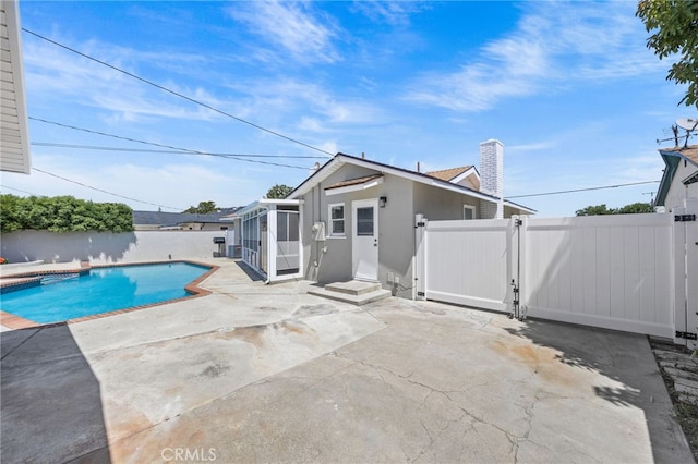 1514 E Palm Ave, Orange, CA 92866 - rear view of property with a gate, a patio area, stucco siding, a chimney, and a sunroom