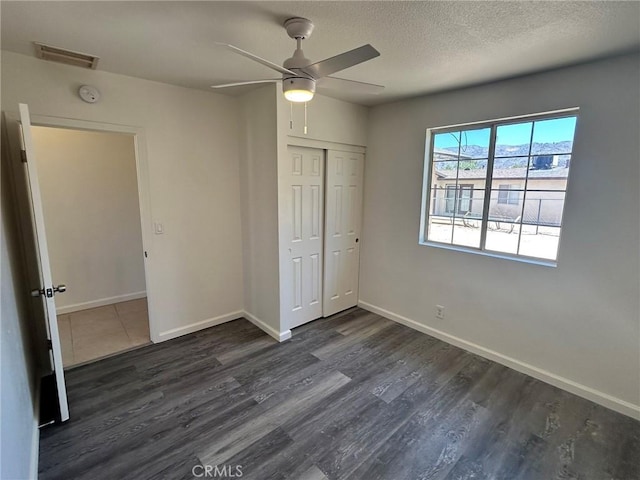 6162 Chia Ave Unit 29, Palms, CA 92277 - unfurnished bedroom with dark wood-style flooring, a closet, a ceiling fan, and a textured ceiling