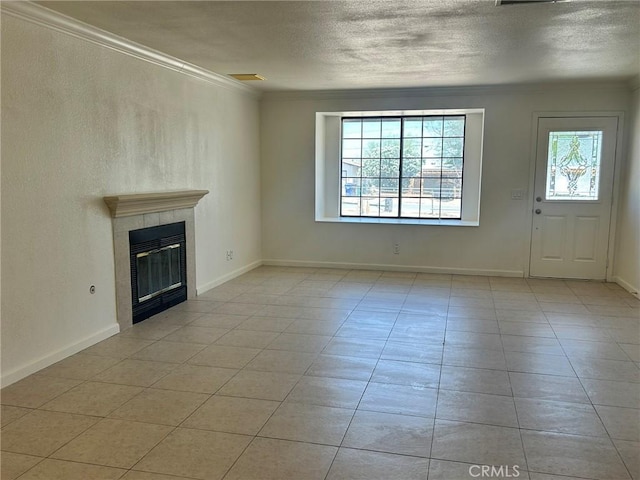 6162 Chia Ave Unit 29, Palms, CA 92277 - unfurnished living room featuring a textured ceiling, crown molding, a tiled fireplace, and light tile patterned flooring
