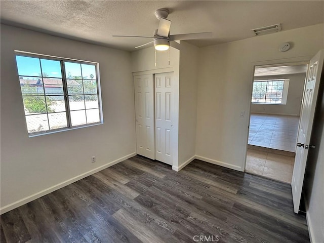 6162 Chia Ave Unit 29, Palms, CA 92277 - unfurnished bedroom with dark wood finished floors, a closet, a ceiling fan, and a textured ceiling