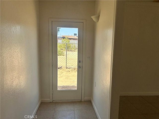 6162 Chia Ave Unit 29, Palms, CA 92277 - doorway to outside with light tile patterned flooring and baseboards