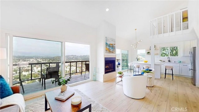 496 Crane Blvd, Los Angeles, CA 90065 - living area featuring light wood-type flooring, a towering ceiling, and a multi sided fireplace