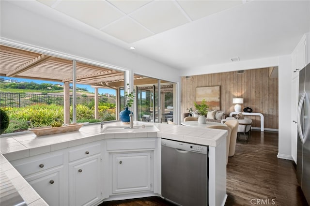 1606 Reef View Cir, Corona Del Mar, CA 92625 - kitchen with appliances with stainless steel finishes, tile countertops, wood walls, open floor plan, and white cabinetry