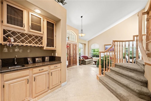 31148 Kahwea Rd, Temecula, CA 92591 - kitchen with high vaulted ceiling, open floor plan, glass insert cabinets, dark stone counters, and decorative light fixtures