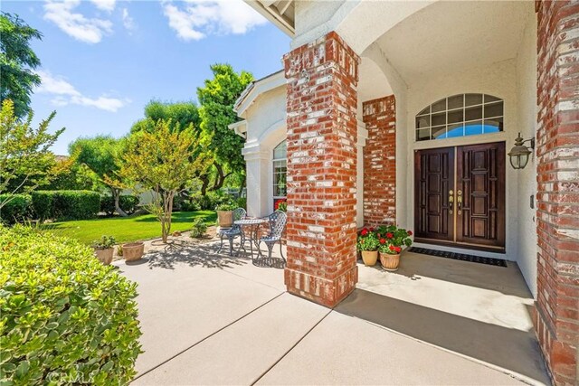 31148 Kahwea Rd, Temecula, CA 92591 - doorway to property with brick siding, stucco siding, and a yard