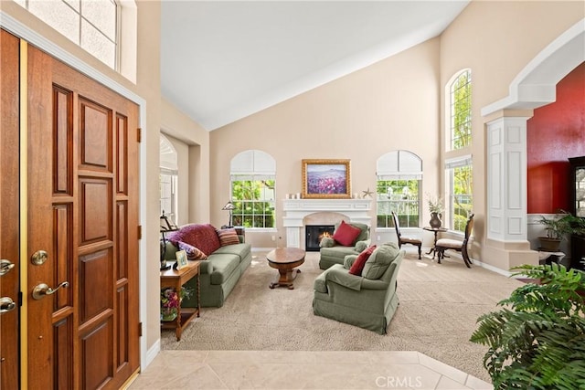 31148 Kahwea Rd, Temecula, CA 92591 - carpeted living area with high vaulted ceiling, a lit fireplace, and plenty of natural light