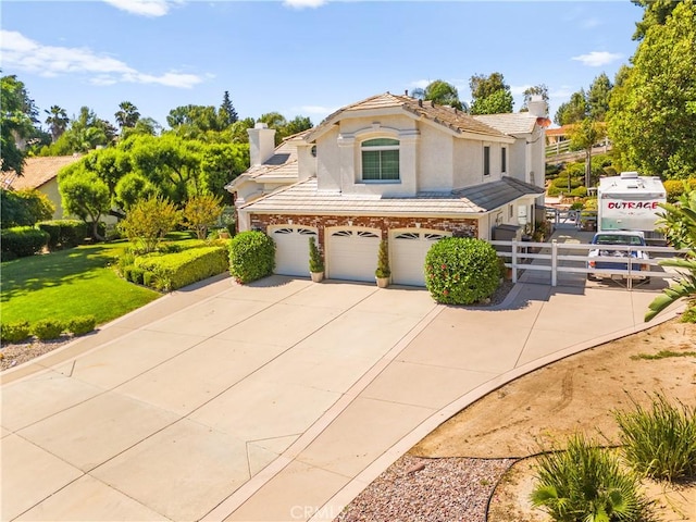 31148 Kahwea Rd, Temecula, CA 92591 - view of front facade featuring a chimney, stucco siding, an attached garage, a tiled roof, and concrete driveway