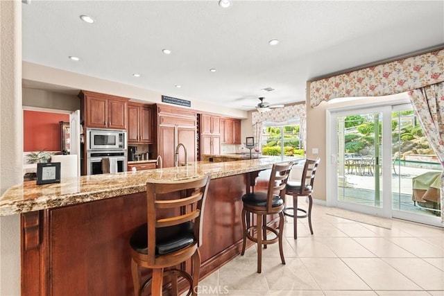 31148 Kahwea Rd, Temecula, CA 92591 - kitchen with built in appliances, a ceiling fan, light stone countertops, a kitchen bar, and recessed lighting