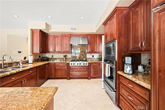 31148 Kahwea Rd, Temecula, CA 92591 - kitchen with appliances with stainless steel finishes, a warming drawer, wall chimney exhaust hood, light stone counters, and decorative backsplash