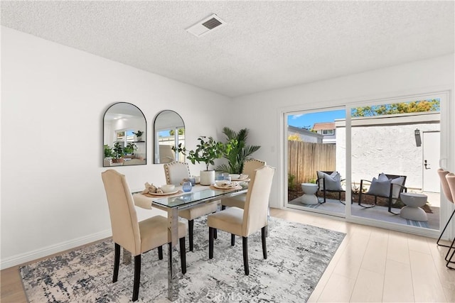11338 Grand Manan Dr, Cypress, CA 90630 - dining room featuring a textured ceiling, plenty of natural light, and wood finished floors