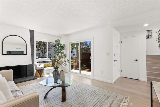 11338 Grand Manan Dr, Cypress, CA 90630 - living area featuring a textured ceiling, wood finished floors, and a premium fireplace