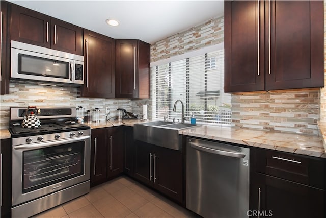 13632 Valerio St Unit 2, Van Nuys, CA 91405 - kitchen with appliances with stainless steel finishes, tile patterned floors, tasteful backsplash, light stone counters, and dark brown cabinetry