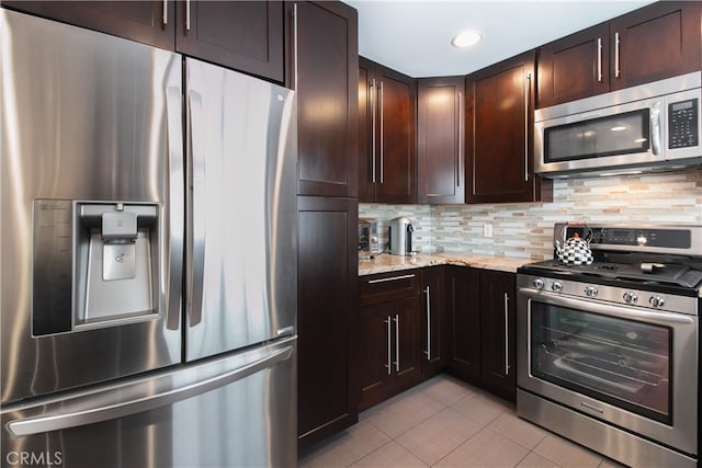 13632 Valerio St Unit 2, Van Nuys, CA 91405 - kitchen featuring appliances with stainless steel finishes, light tile patterned flooring, backsplash, dark brown cabinetry, and light stone countertops