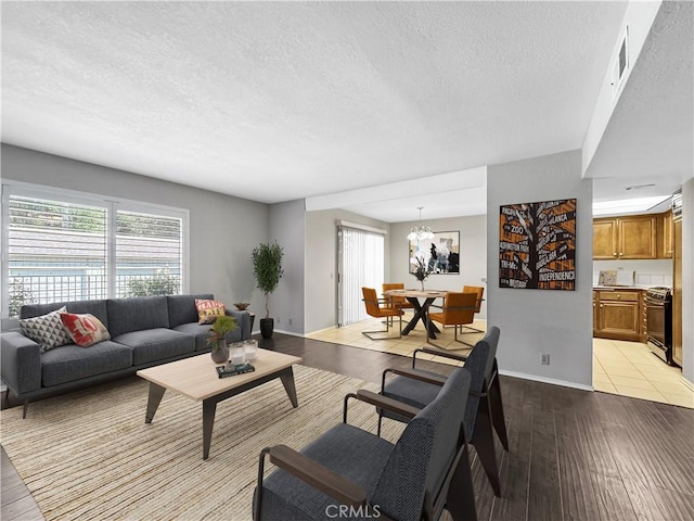 600 Central Ave Unit 323, Riverside, CA 92507 - living area with light wood finished floors, a textured ceiling, plenty of natural light, and a chandelier