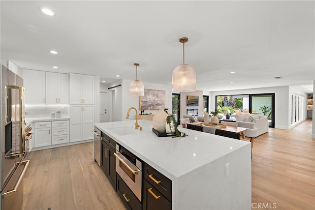 31842 Paseo Cielo, San Juan Capistrano, CA 92675 - kitchen featuring light wood-type flooring, white cabinetry, appliances with stainless steel finishes, a kitchen island with sink, and recessed lighting