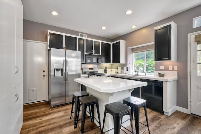 339 Diamante Way, Oceanside, CA 92056 - kitchen with black appliances, dark cabinetry, a kitchen bar, light countertops, and recessed lighting