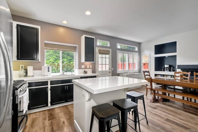 339 Diamante Way, Oceanside, CA 92056 - kitchen featuring gas stove, dark cabinetry, a kitchen bar, freestanding refrigerator, and recessed lighting