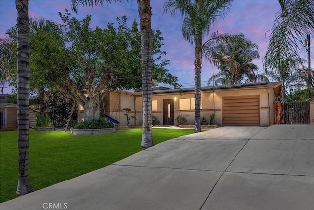 2818 Renegade Ave, Bakersfield, CA 93306 - view of front of property featuring concrete driveway, an attached garage, stucco siding, and a lawn