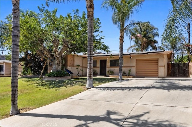 2818 Renegade Ave, Bakersfield, CA 93306 - view of front facade featuring driveway, a garage, solar panels, and stucco siding