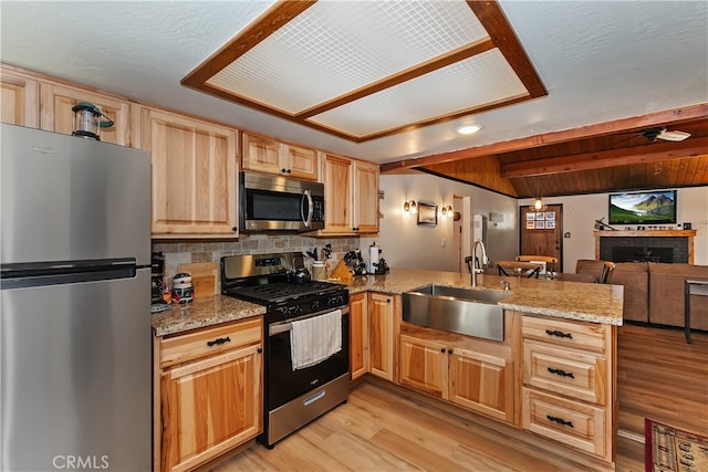721 Riverside Ave, Sugarloaf, CA 92386 - kitchen featuring stainless steel appliances, light brown cabinets, a peninsula, light wood-type flooring, and backsplash