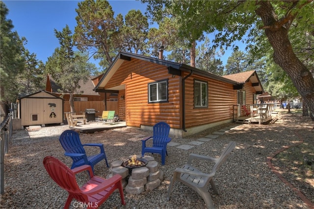 721 Riverside Ave, Sugarloaf, CA 92386 - rear view of property with an outdoor fire pit, a wooden deck, a shed, faux log siding, and a patio area