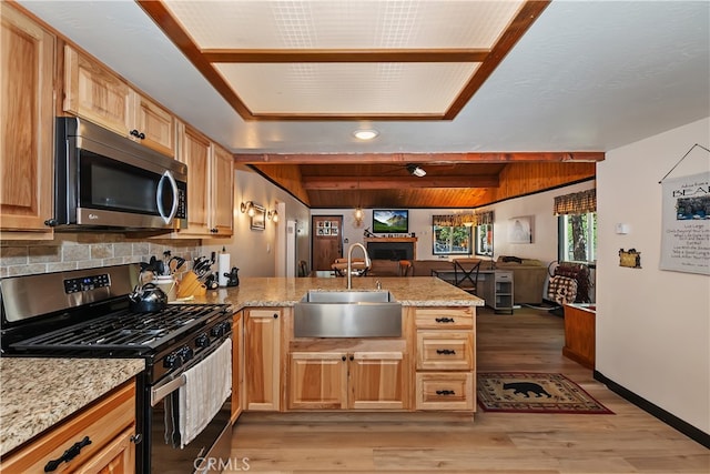 721 Riverside Ave, Sugarloaf, CA 92386 - kitchen featuring appliances with stainless steel finishes, a peninsula, open floor plan, light wood finished floors, and light stone countertops