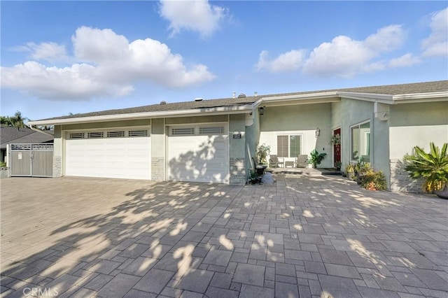 1817 Balboa Way, Upland, CA 91784 - view of front of house with decorative driveway, an attached garage, stucco siding, and stone siding