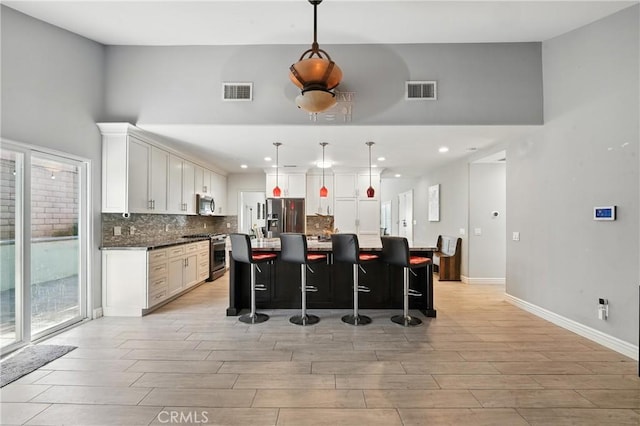 1817 Balboa Way, Upland, CA 91784 - kitchen with stainless steel appliances, light wood finished floors, tasteful backsplash, a kitchen breakfast bar, and a high ceiling