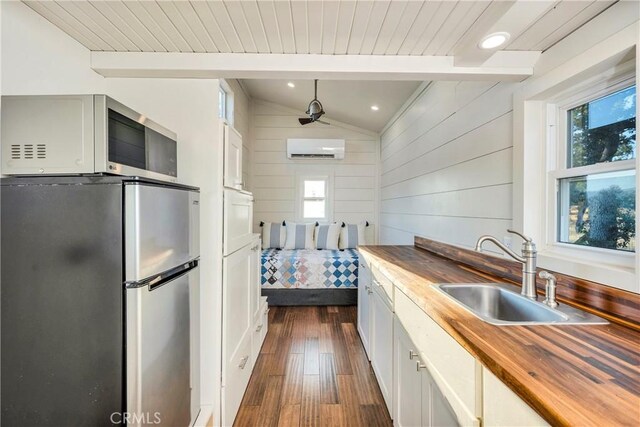 21018 Yankee Valley Rd, Hidden Valley Lake, CA 95467 - kitchen with freestanding refrigerator, wood counters, a wall mounted AC, dark wood-type flooring, and wooden walls