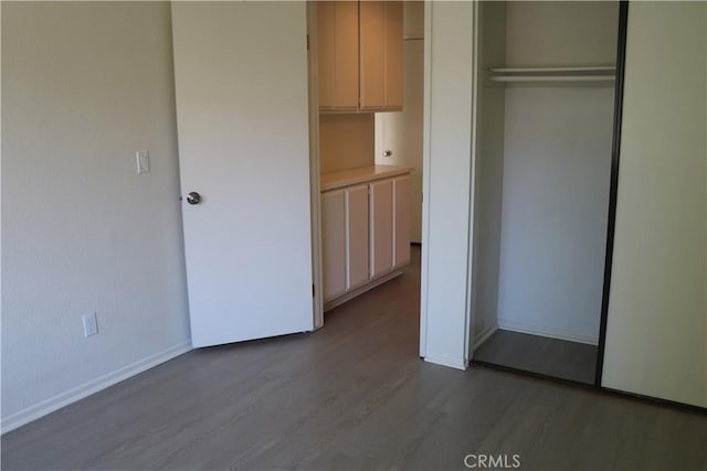 80 Greenmoor Unit 40, Irvine, CA 92614 - unfurnished bedroom featuring dark wood-style floors and a closet